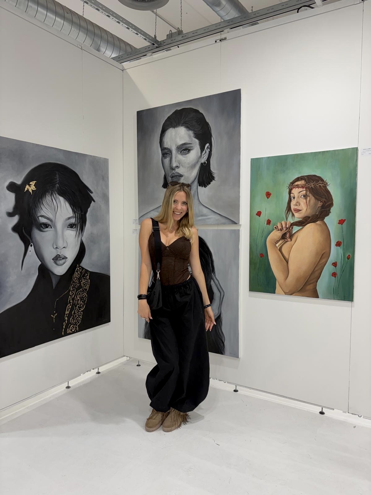 Daniela Lapera in front of her paintings at an exhibition